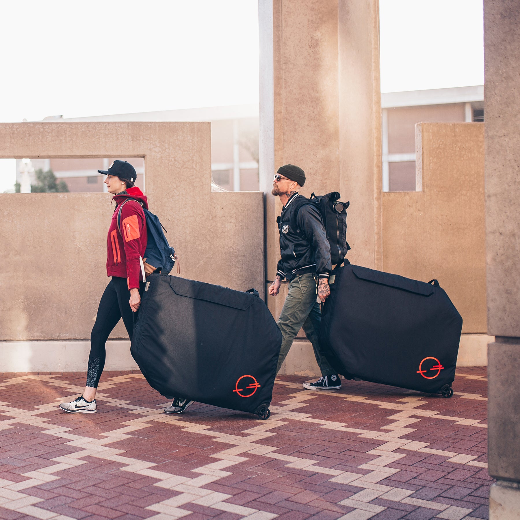 2 people rolling the Post Carry Co. Transfer Case through a transit terminal