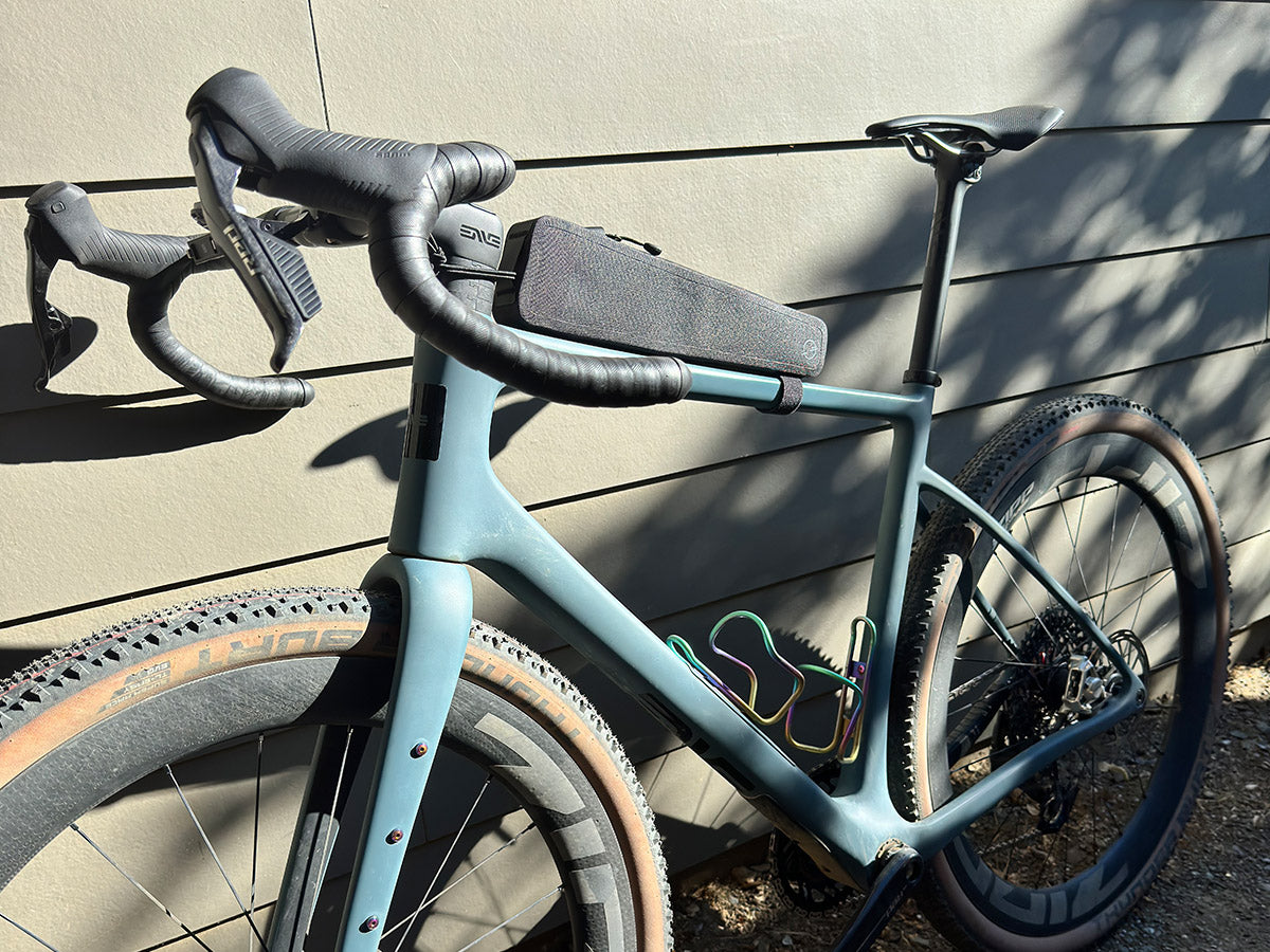 The Post Carry Co. Top Tube Pack mounted above the top tube of an Enve gravel bike shown from the side