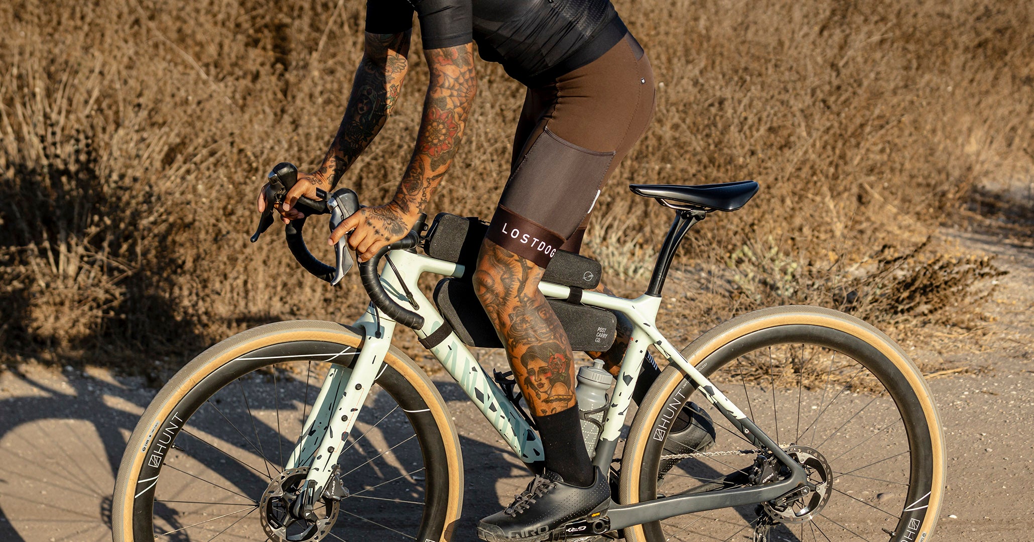 Side view of the Post Carry Co. Slim Frame Pack and Top Tube Pack mounted on a bicycle while the rider is pedaling